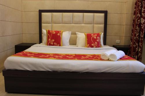 a bedroom with a large bed with red pillows at Trimrooms Katra Railway Station in Katra