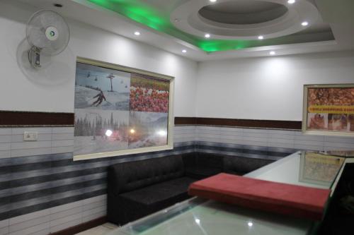 a waiting room with a couch and green lights at Trimrooms Katra Railway Station in Katra