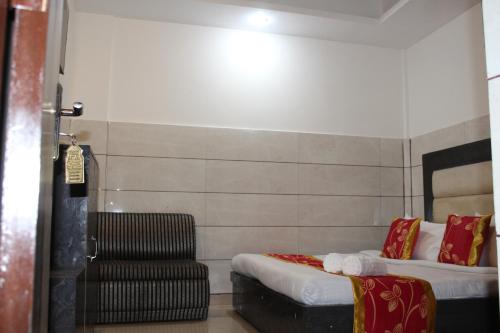 a hotel room with two beds and a chair at Trimrooms Katra Railway Station in Katra