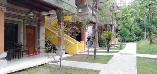 a building with a table and chairs outside of it at Melasti Kuta Bungalows & Spa in Kuta