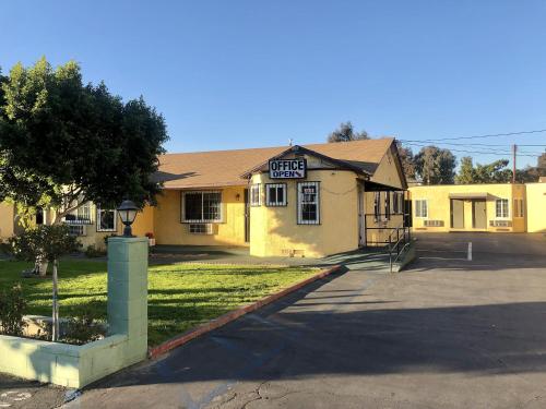 un bâtiment jaune avec un panneau à l'avant dans l'établissement Deluxe Inn, à Pomona
