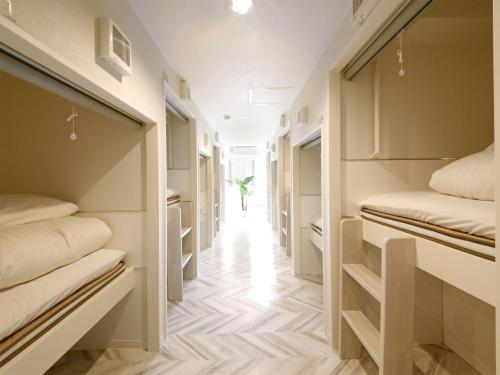 a hallway of walk in closets with beds at Lestel Maru in Sapporo