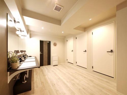 an empty hallway with white walls and wood floors at Lestel Maru in Sapporo