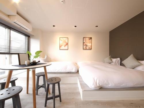 a bedroom with a bed and a table and chairs at Lestel Maru in Sapporo