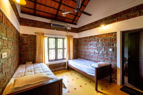 een slaapkamer met 2 bedden en een raam bij Cynefin, Pet-friendly 2br by the backwaters by Roamhome in Murinjupuzha