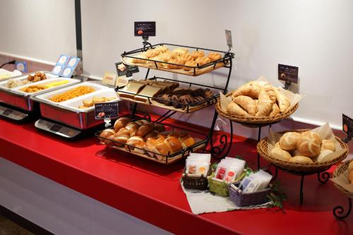 a buffet of bread and pastries on a red counter at HOTEL Guest1 Ueno Ekimae in Tokyo