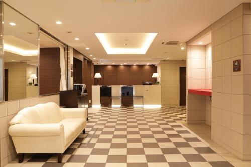 a lobby with a white chair and a checkered floor at HOTEL Guest1 Ueno Ekimae in Tokyo