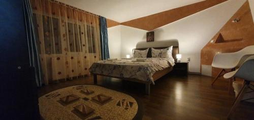 a bedroom with a bed and a large window at Apartament Casa Teo in Şarul Dornei
