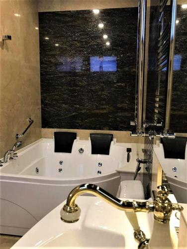 a bathroom with a sink and a bath tub at Hotel Agava in Tbilisi City
