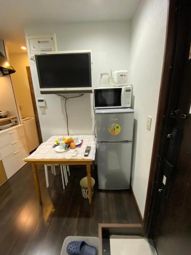 a small kitchen with a table and a microwave at Takemura Building 2nd floor in Tokyo