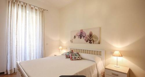 Habitación blanca con cama y ventana en Castellabate Apartments Casa Maddalena, en Castellabate