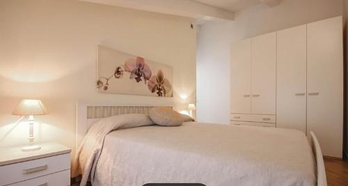 1 dormitorio con 1 cama blanca y armario blanco en Castellabate Apartments Mansarda Maddalena en Castellabate