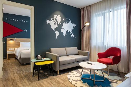 a hotel room with a couch and a world map on the wall at Ibis Saigon Airport in Ho Chi Minh City