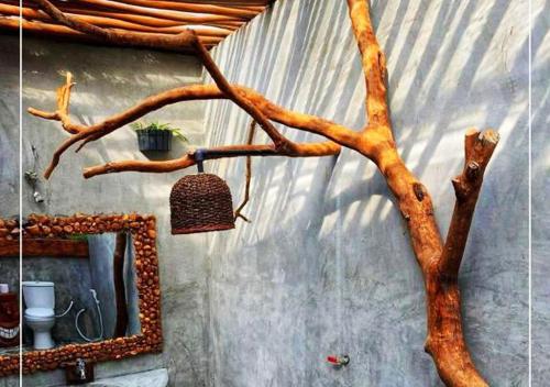 a tree branch with a mirror and a basket on a wall at Dream Ville in Ella