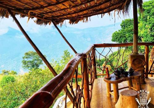 a balcony of a hut with a table and a view at Dream Ville in Ella