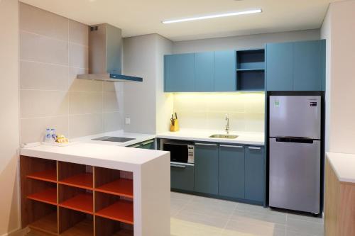 a kitchen with blue cabinets and a refrigerator at Ibis Saigon Airport in Ho Chi Minh City