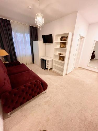 a living room with a red couch and a television at COCHET BOUTIQUE in Târgu Jiu