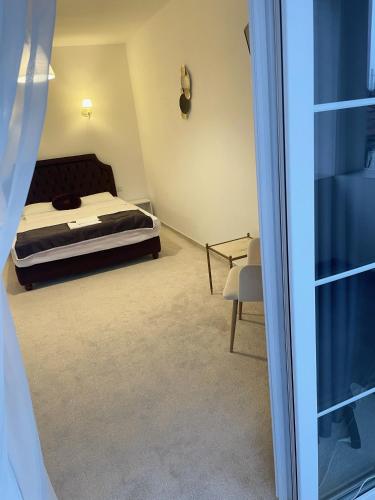 a bedroom with a bed and a glass door at COCHET BOUTIQUE in Târgu Jiu