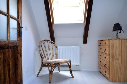 a chair in a room with a window and a dresser at Apartmány Kojákovice - Třeboň in Jílovice