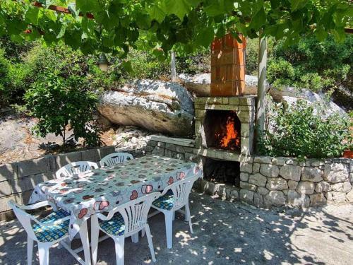 a table and chairs in front of a stone oven at Apartments Maruška in Sobra