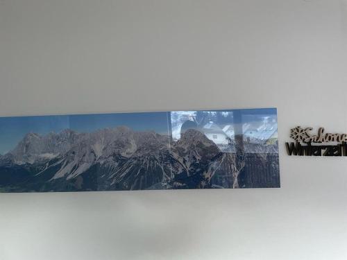 two photographs of a mountain range on a wall at Naturpark Appartment in Ratting