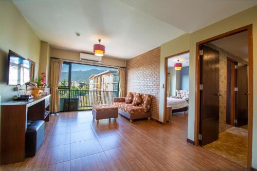 a living room with a couch and a balcony at WE Valley Hotel in Chiang Mai