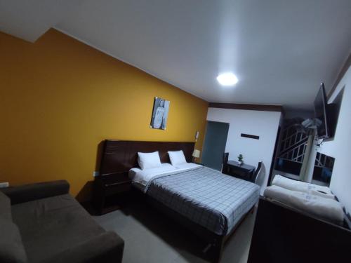 a bedroom with a bed and a couch in it at Hotel Santa Maria in Ica