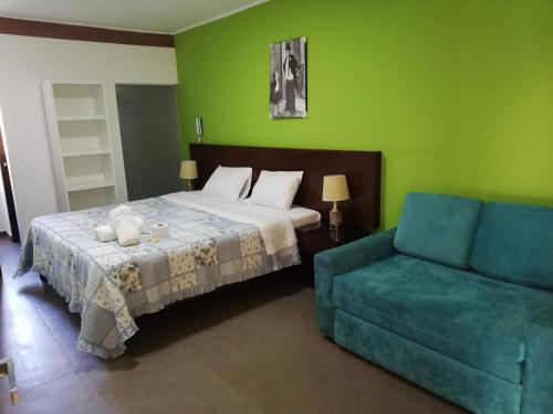 a bedroom with a bed and a blue couch at Hotel Santa Maria in Ica