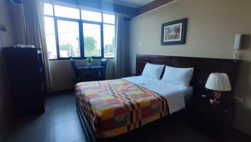a hotel room with a bed and a window at Hotel Santa Maria in Ica