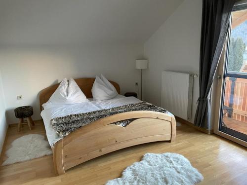 Naturpark Appartment في Großsölk: سرير مع اطار خشبي في الغرفة