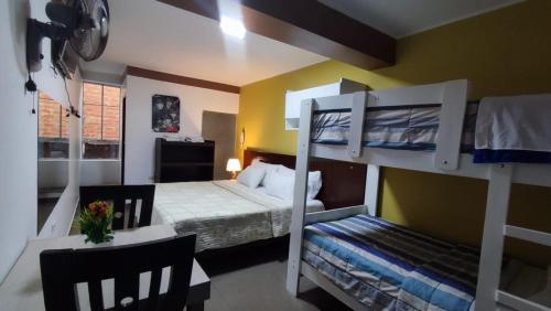 a bedroom with two bunk beds and a table and chairs at Hotel Santa Maria in Ica