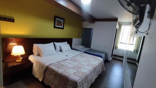 a bedroom with a bed and a lamp in it at Hotel Santa Maria in Ica