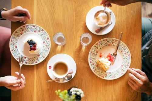 a table with plates of food and a cup of coffee at Hotel Gotthard in Lech am Arlberg