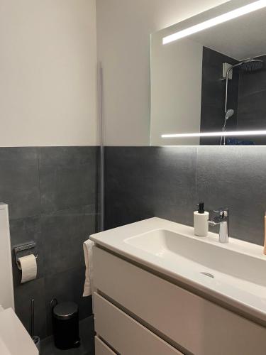 ein Badezimmer mit einem weißen Waschbecken und einem Spiegel in der Unterkunft Ansàna in Lenz