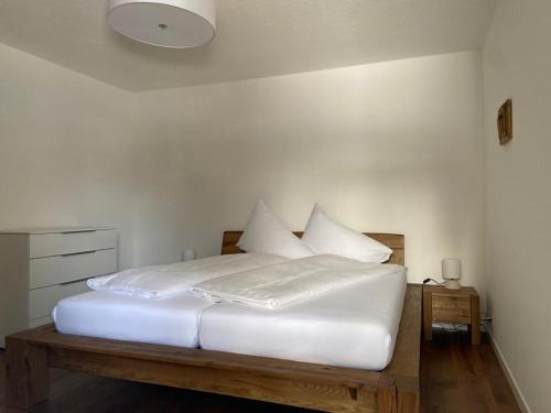 - un lit blanc avec des draps et des oreillers blancs dans l'établissement Ansàna, à Lenz