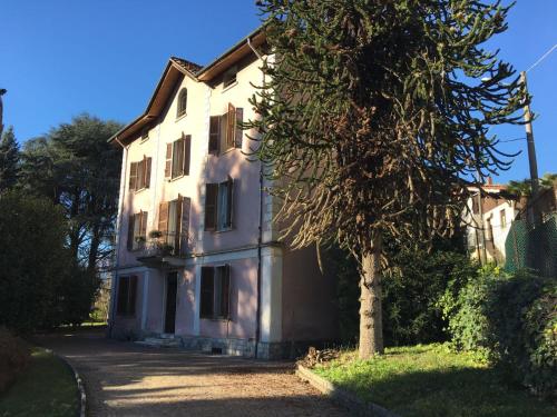 une maison blanche avec un arbre en face dans l'établissement Villa Monica, à Luino
