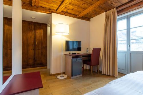 a bedroom with a desk with a computer and a bed at Le Rive Sud in Estavayer-le-Lac