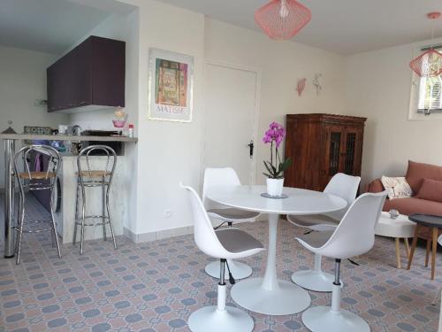 un salon avec une table et des chaises blanches dans l'établissement Pool House Matisse in large park with heated pool, à Châteauneuf