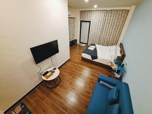 uma sala de estar com um sofá e uma televisão em Rainy Pleasure em Meishan