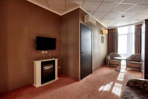 ein Hotelzimmer mit einem TV an der Wand in der Unterkunft Bogemia Hotel on Vavilov Street in Saratow