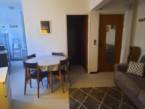 un salon avec une table, des chaises et un canapé dans l'établissement Studio rénové au cœur du village, à Saint-Martin-Vésubie