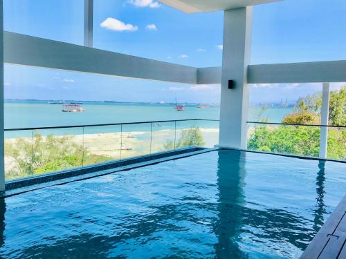 een zwembad met uitzicht op de oceaan bij SUNRISE Gurney Seaview Luxury Duplex in George Town