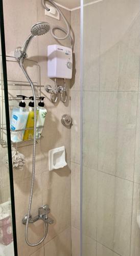 a shower in a bathroom with a glass door at Hola! Condotel @ Inspiria Davao in Davao City