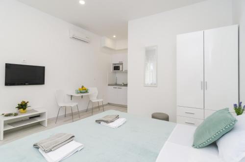 a white room with a bed and a tv at Apartment Rafaello in Dubrovnik
