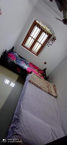 una habitación con dos camas y una ventana en NARAYANALAYAM-Vintage Retreat-Homestay & Rest'Inn, en Kannur