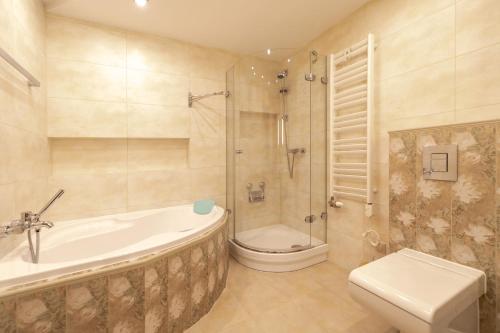 a bathroom with a tub and a shower and a toilet at Apartament Na Wzgórzu z widokiem na góry - Dream Apart in Wisła