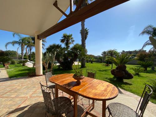 a wooden table and chairs on a patio at VILLA ADA pool residence in Veglie