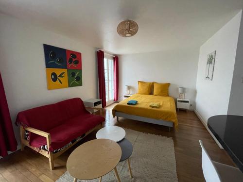 ein Schlafzimmer mit einem Bett und einem roten Sofa in der Unterkunft La Catène-Perret in Le Havre