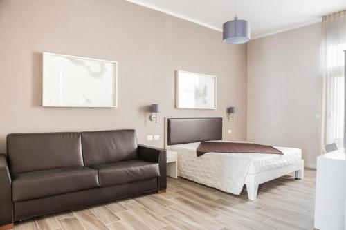 a living room with a bed and a couch at Faro Bianco Gallipoli - Suites & Apartments in Gallipoli