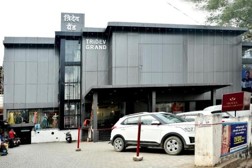 a white car parked in front of a shopping center at HOTEL TRIDEV GRAND in Varanasi